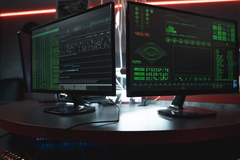 ECDSA Curve Origins: New Analysis Pushes Back on the NIST Backdoor Theory Dual computer monitors displaying code in a dark room